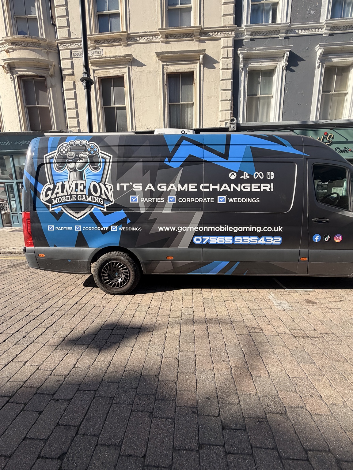 The real Game On van and its original blue, black and grey wrap